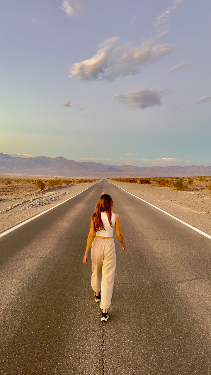Picture of a beautiful girl walking on the road in Death Valley, California, USA.
